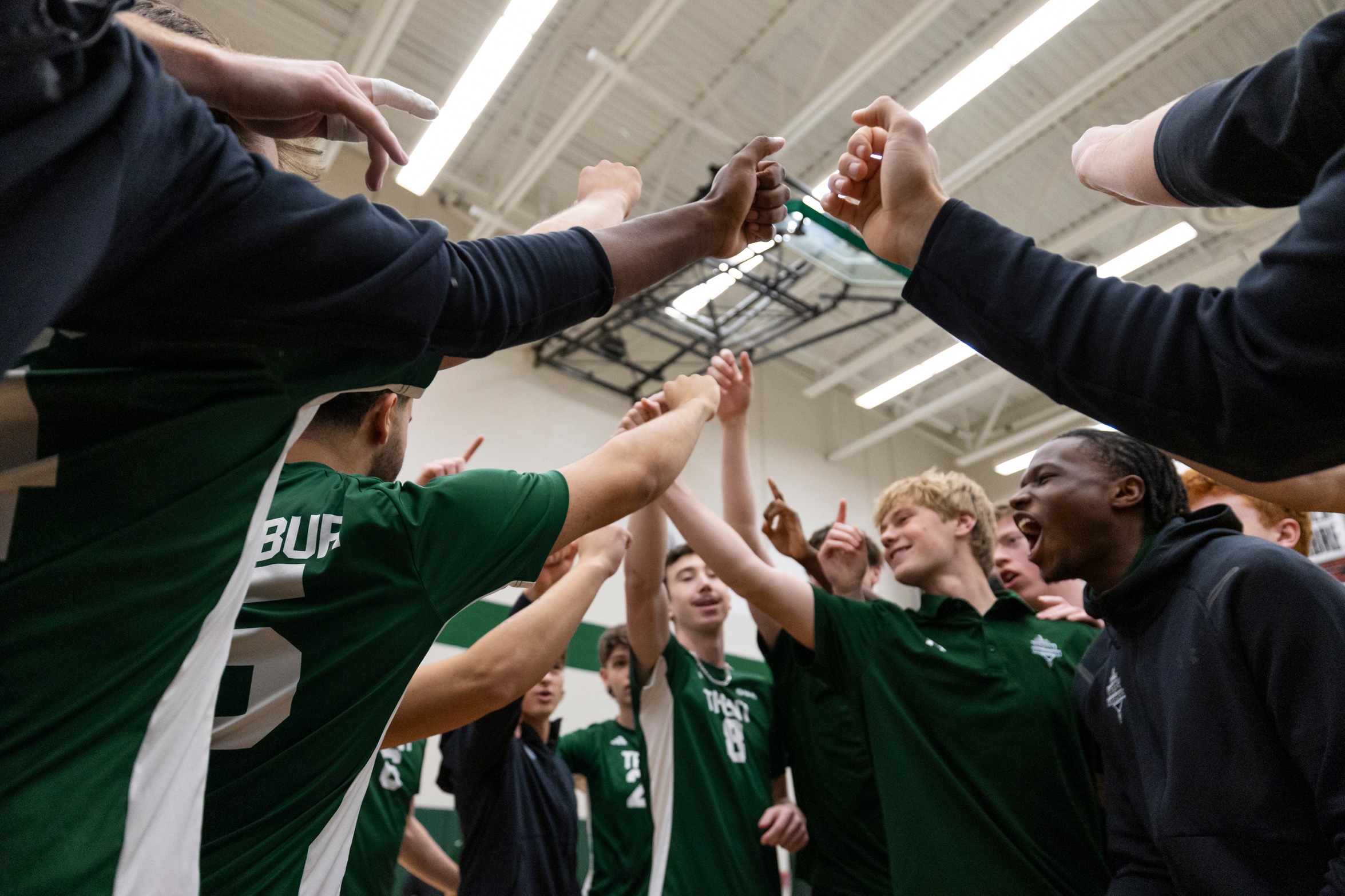 members of the men's volleyball team in a huddle
