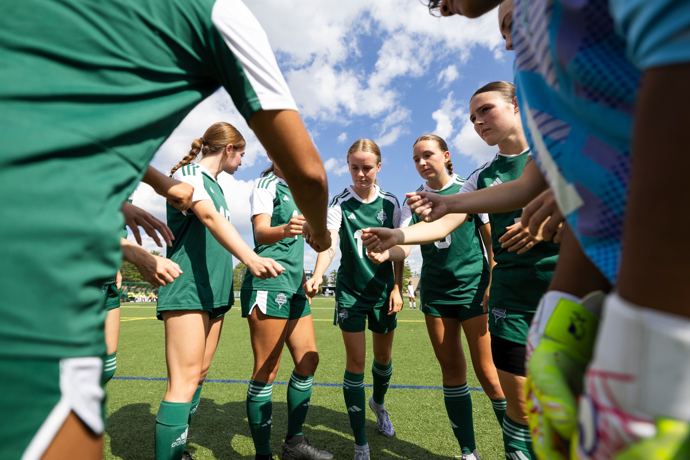 Excalibur women's soccer team in a huddle on the field